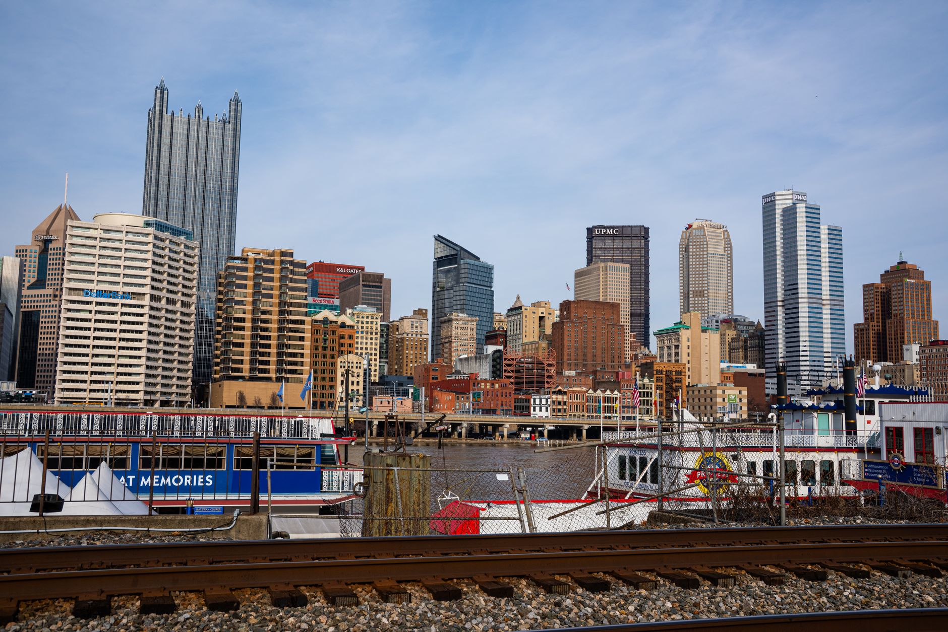 Rusted steel mill structure with tall smokestacks against a cloudy Pittsburgh sky